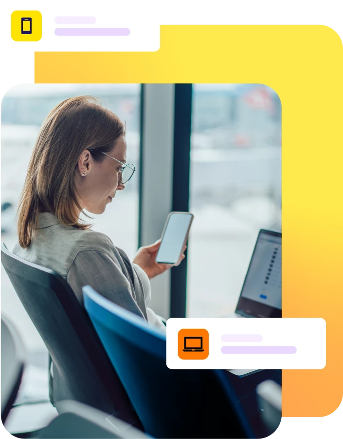 Lady sat at an airport using a laptop and mobile phone